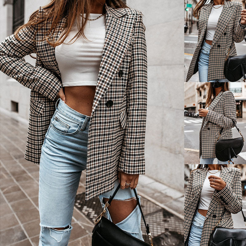 Woman wearing a plaid blazer, white top, and light blue jeans on a city street.